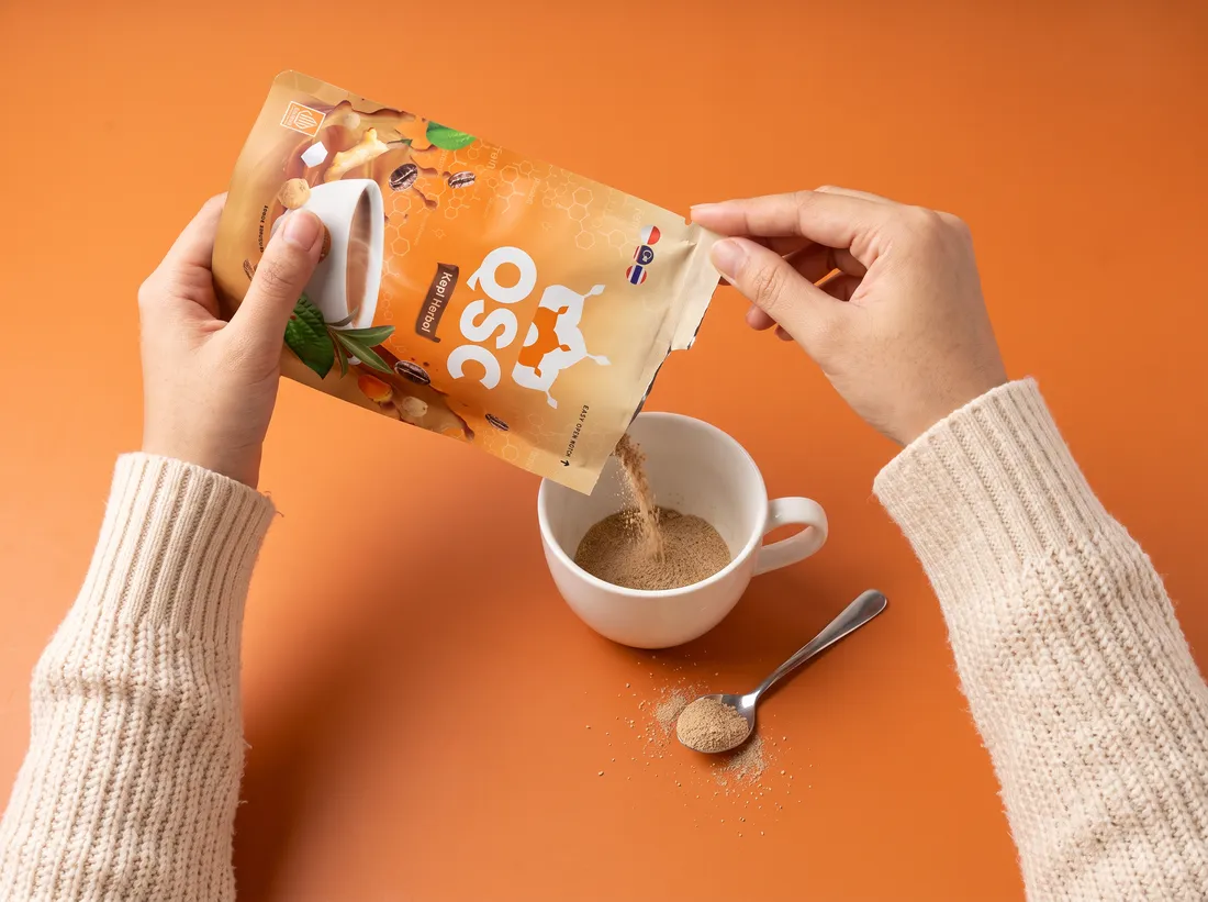 Tangan menuang serbuk QSC dari pouch ke cangkir